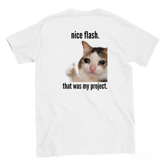 Back view of a white bouldering T-shirt featuring Nice Flash. That Was My Project. text and a crying cat giving a thumbs-up.